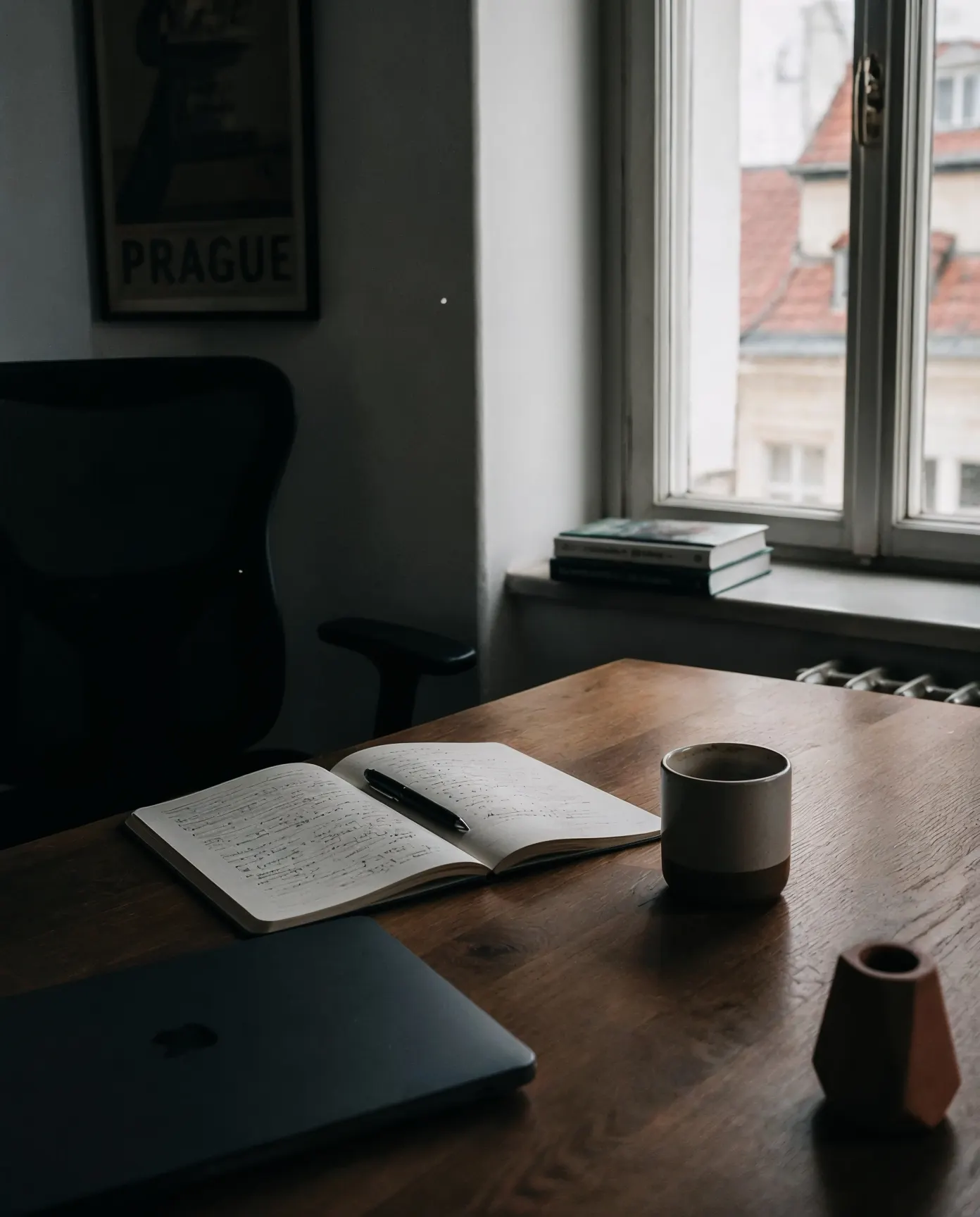 A quiet desk in Prague — open notebook, espresso, afternoon light through the window.